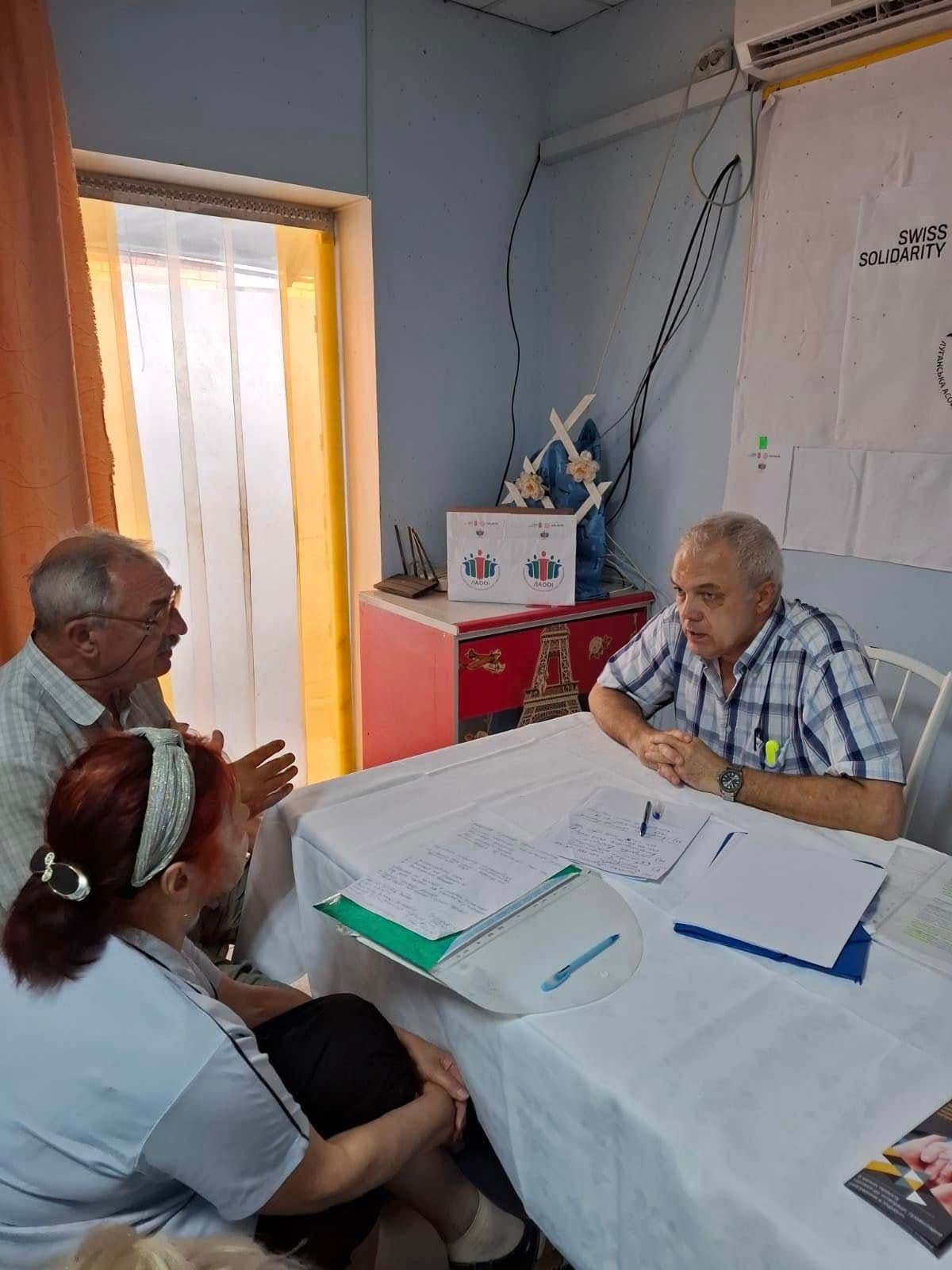 Чоловік і жінка сидять за столом навпроти іншого чоловіка.