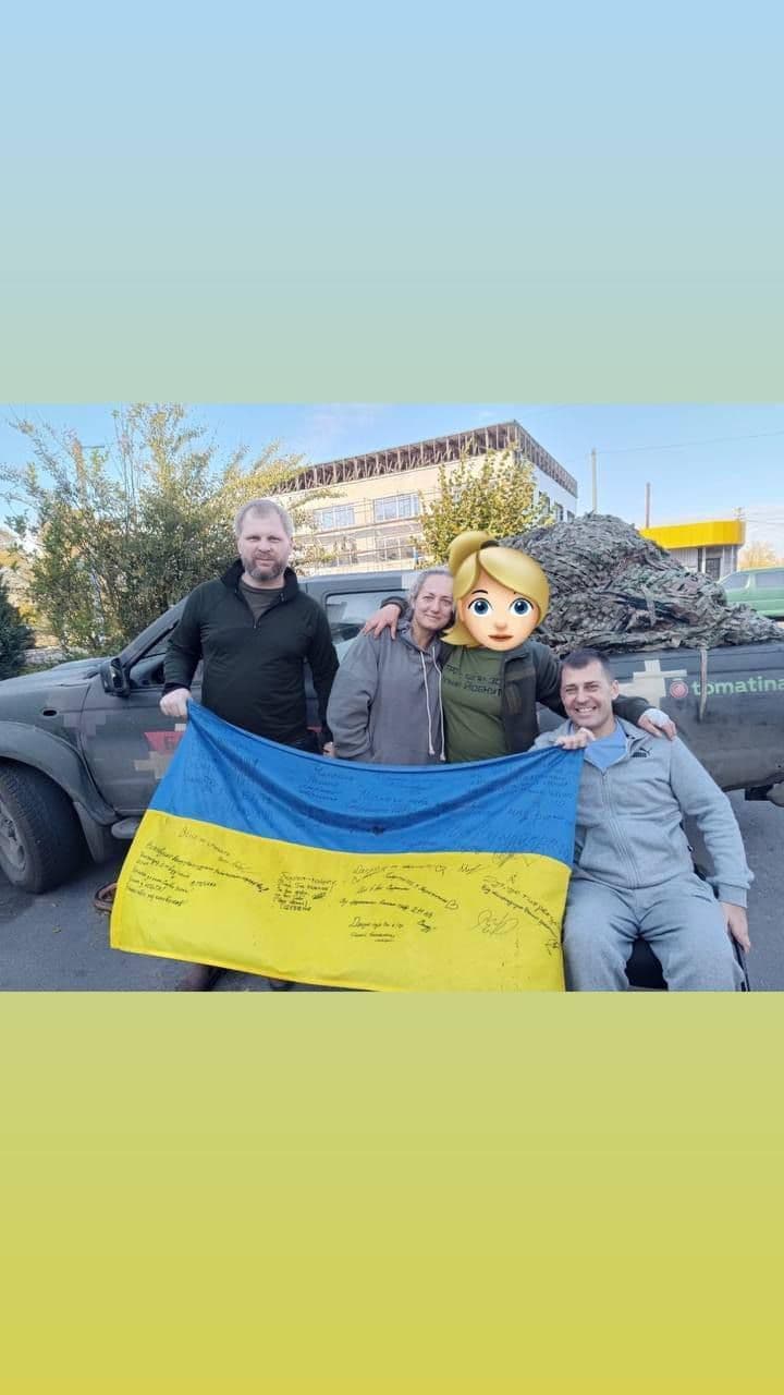 Четверо людей тримають прапор України.