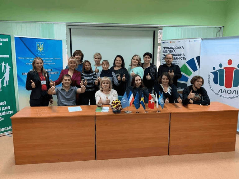Group photo in a room at a table with different flags