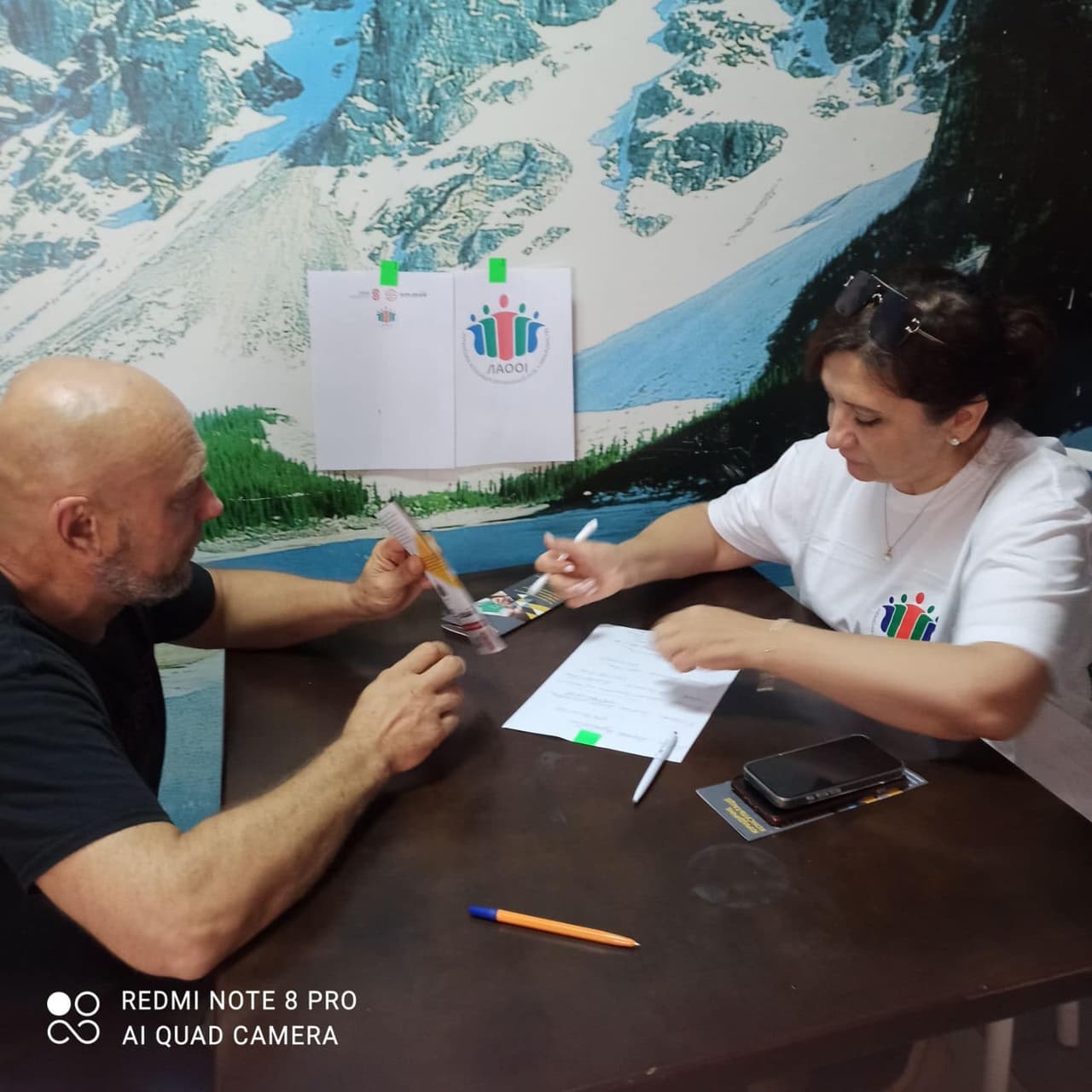 Чоловік та жінка сидять за столом і заповнюють анкету.