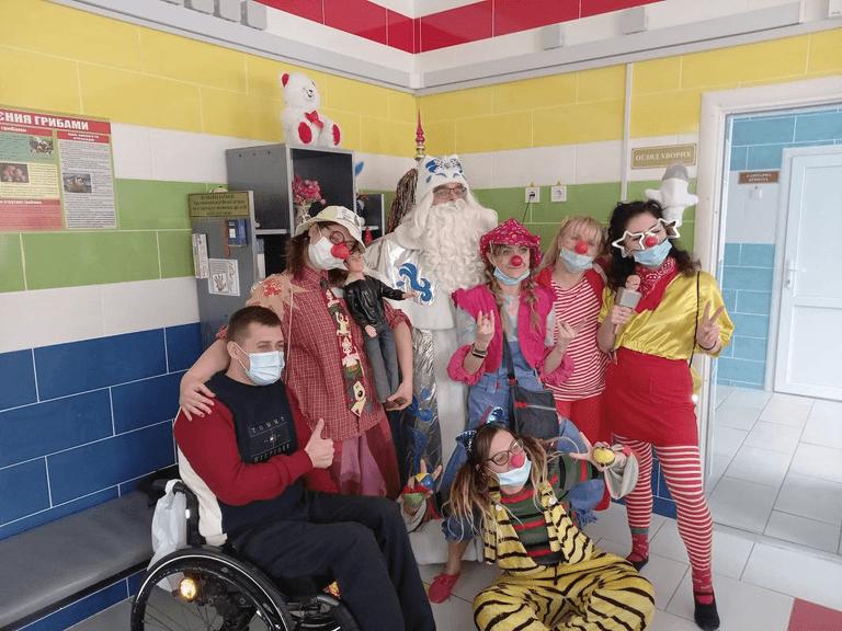 Group photo of people in New Year's attire and a man in a wheelchair