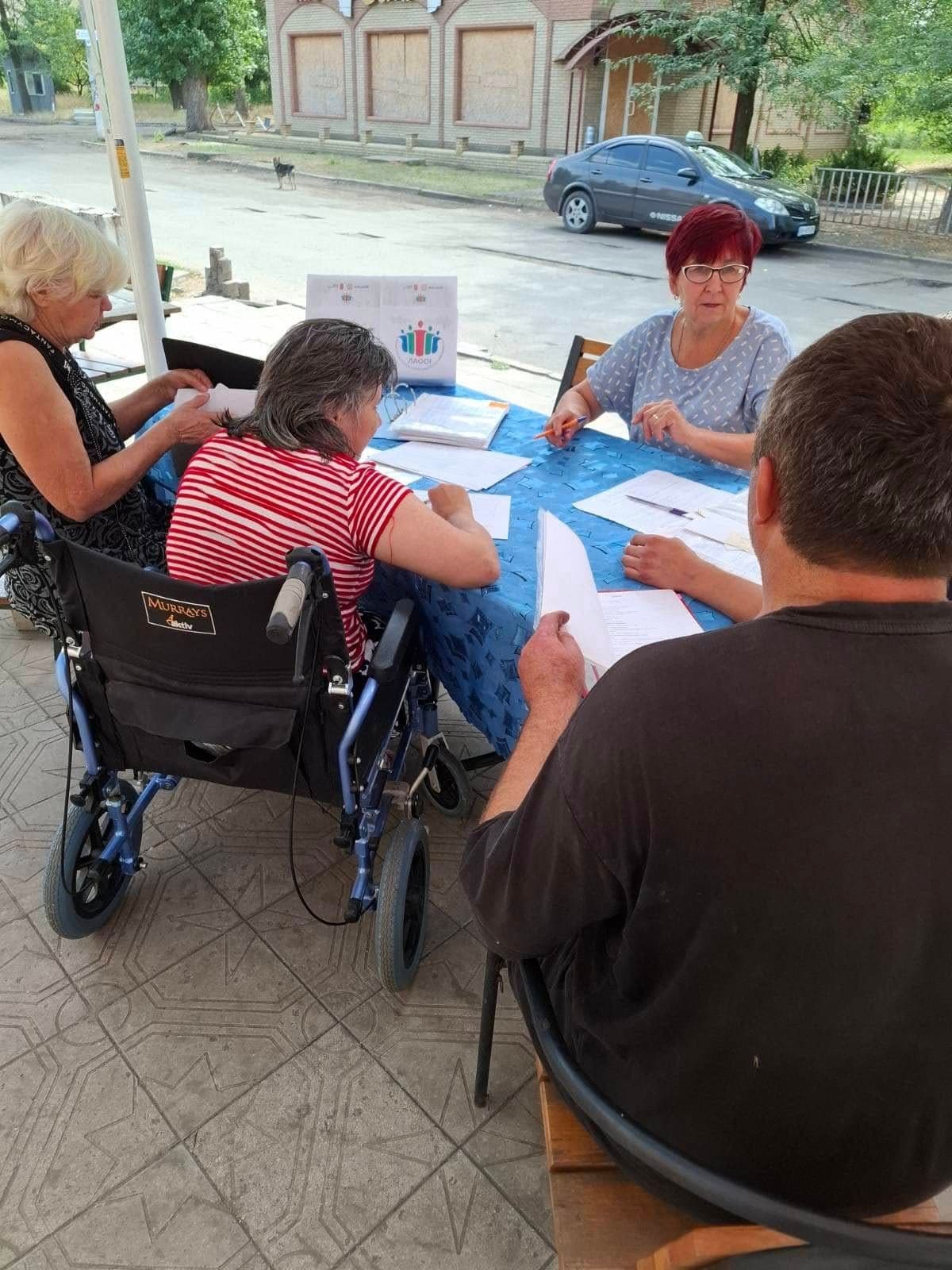 Three women and a man are sitting at a table outdoors.