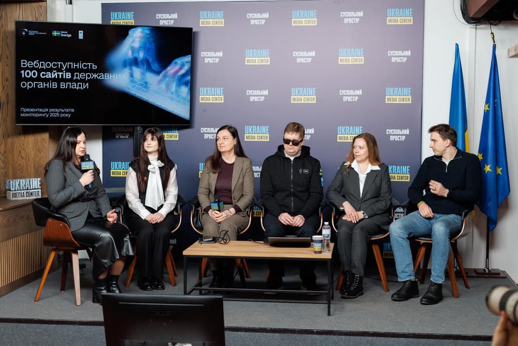 Панельна дискусія у «Ukraine Media Center». На сцені сидять шість учасників, один із них говорить у мікрофон. Позаду — банер із логотипами «UKRAINE MEDIA CENTER» та «Суспільний простір». На великому екрані текст: «Вебдоступність 100 сайтів державних органів влади. Презентація результатів моніторингу 2025 року». Сцена демонструє офіційний захід, присвячений цифровій доступності та прозорості.